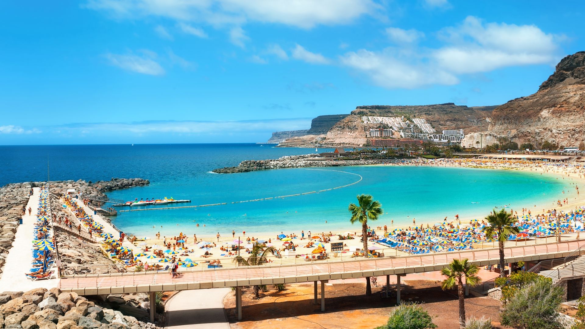 Strand met turquoise water en zonnige hemel.